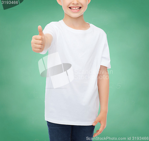 Image of close up of boy in white t-shirt showing thumbs 
