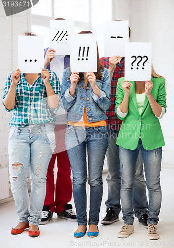 Image of friends or students covering faces with papers