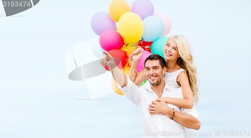 Image of couple with colorful balloons at sea side