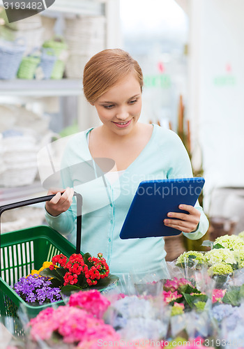 Image of woman with tablet pc and basket at flower shop