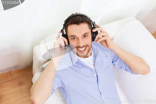 Image of smiling young man in headphones at home