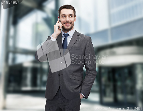 Image of young smiling businessman with smartphone
