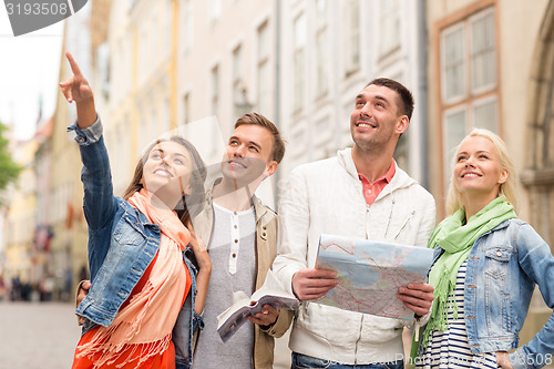 Image of group of smiling friends with city guide and map