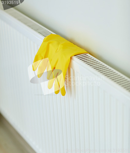 Image of close up of rubber gloves hanging on heater