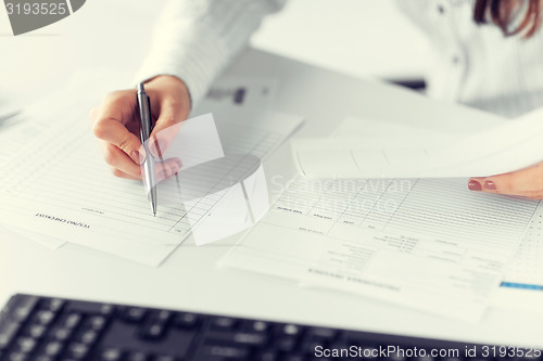 Image of woman hand filling in blank paper or document