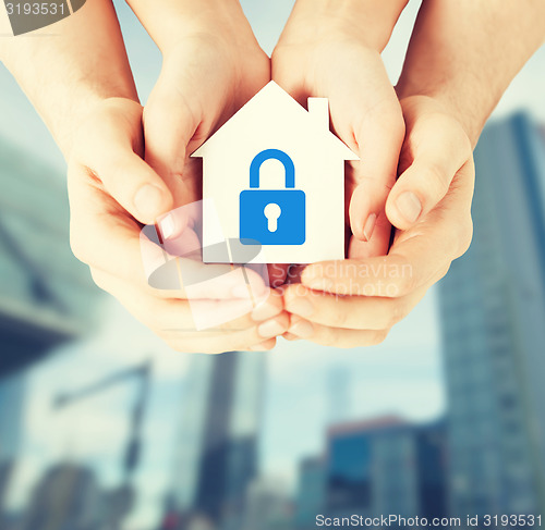 Image of hands holding paper house with lock