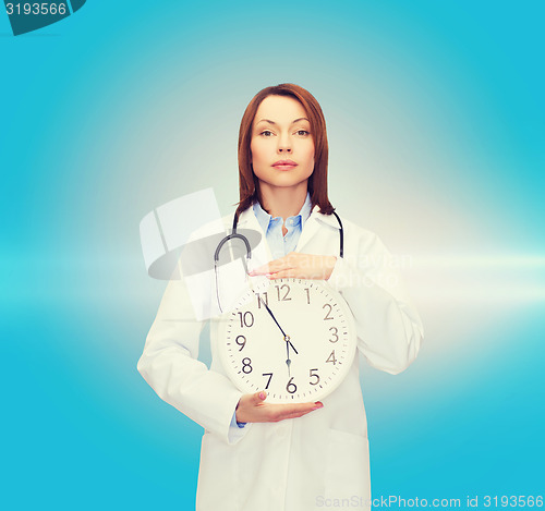 Image of calm female doctor with wall clock