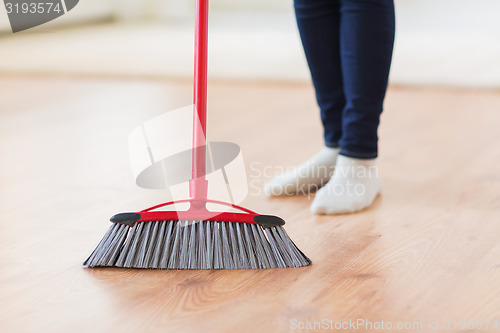 Image of close up of woman legs with broom sweeping floor