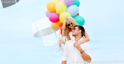 Image of couple with colorful balloons at seaside