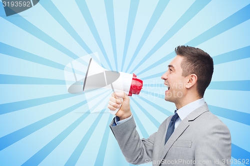 Image of happy businessman in suit speaking to megaphone