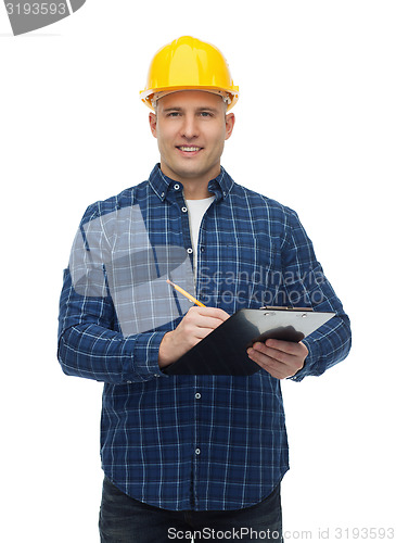 Image of smiling male builder in helmet with clipboard