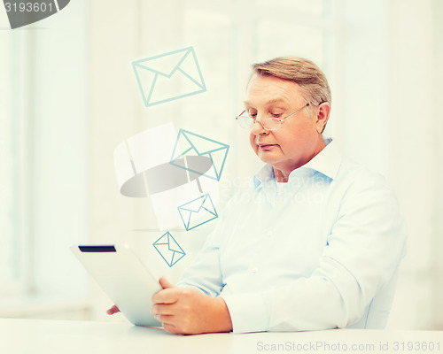 Image of old man with tablet computer at home