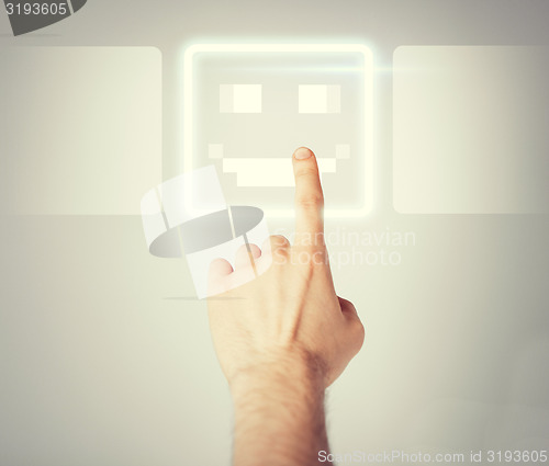 Image of hand touching virtual screen with smile button