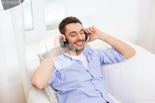 Image of smiling young man in headphones at home