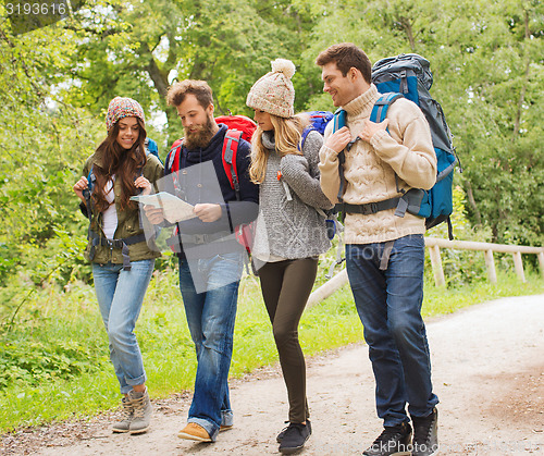 Image of group of smiling friends with backpacks hiking