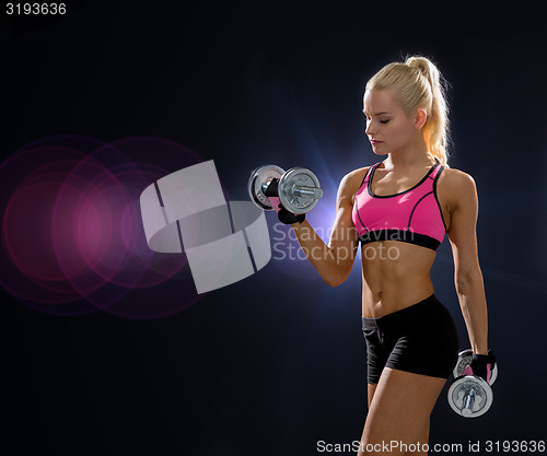 Image of sporty woman with heavy steel dumbbells