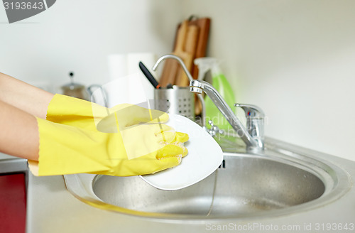 Image of close up of woman hands washing dishes in kitchen