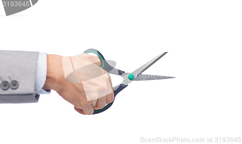 Image of close up of businessman hand holding scissors