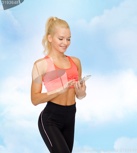 Image of smiling sporty woman with smartphone