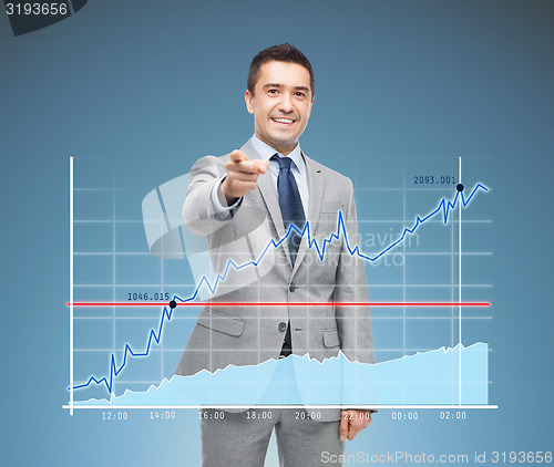 Image of happy smiling businessman in suit pointing at you