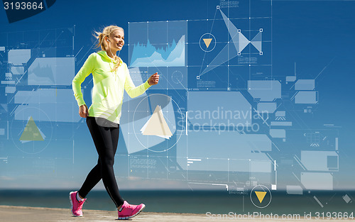 Image of smiling young woman walking outdoors