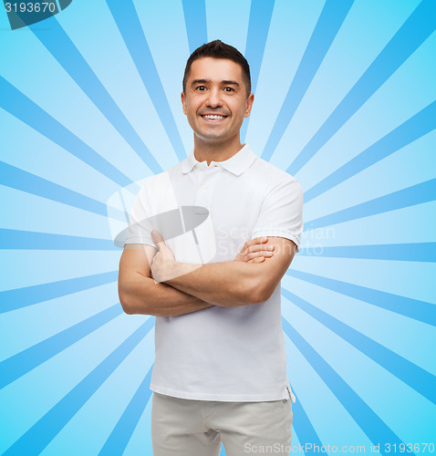 Image of smiling man in white t-shirt with crossed arms