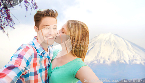 Image of smiling couple with smartphone in city