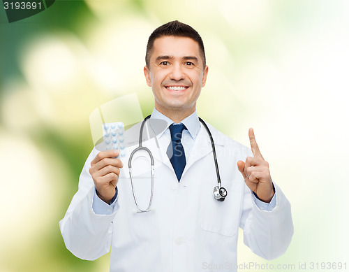 Image of smiling male doctor in white coat with tablets