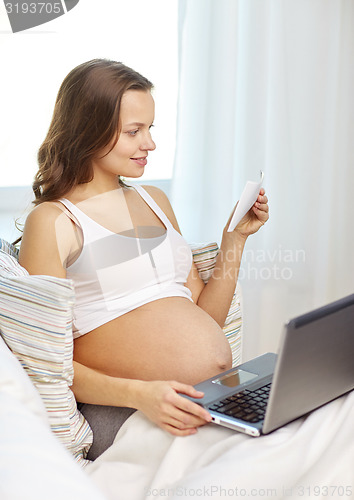 Image of pregnant woman with laptop and ultrasound image