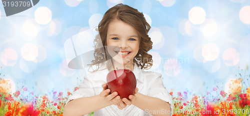 Image of happy girl holding apple over garden background