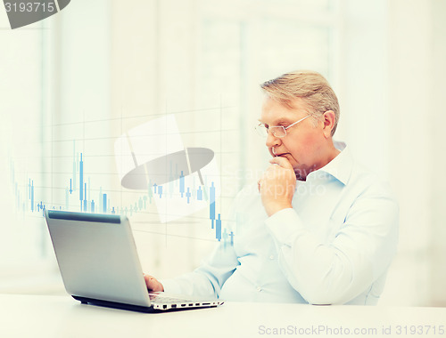 Image of old man in eyeglasses working with laptop at home