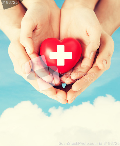 Image of male and female hands with red heart