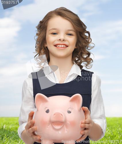 Image of happy girl holding piggy bank