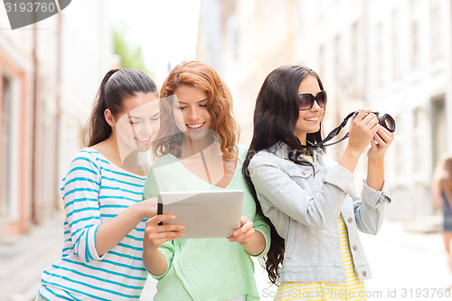 Image of smiling teenage girls with tablet pc and camera