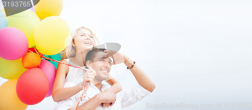 Image of couple with colorful balloons at seaside