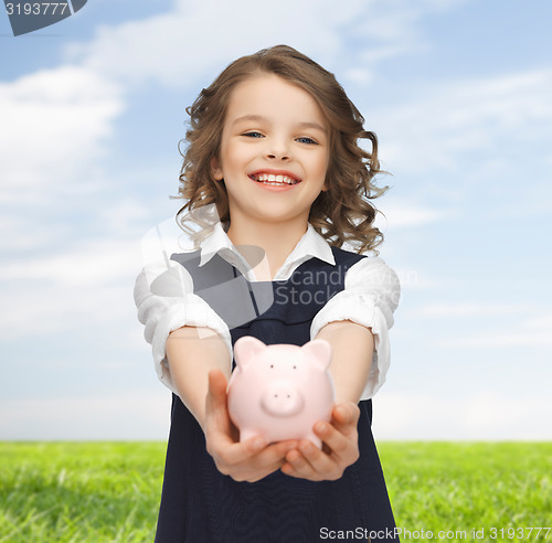 Image of happy girl holding piggy bank on palms