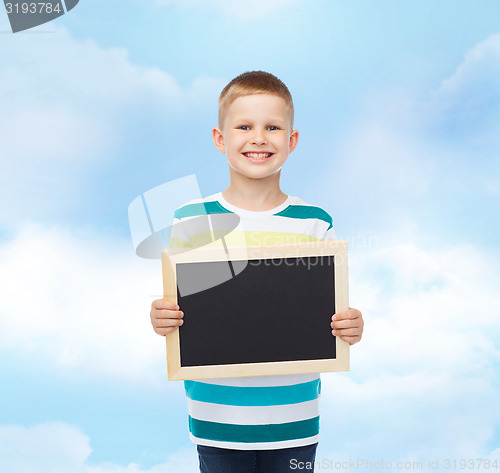 Image of smiling little boy holding blank black chalkboard