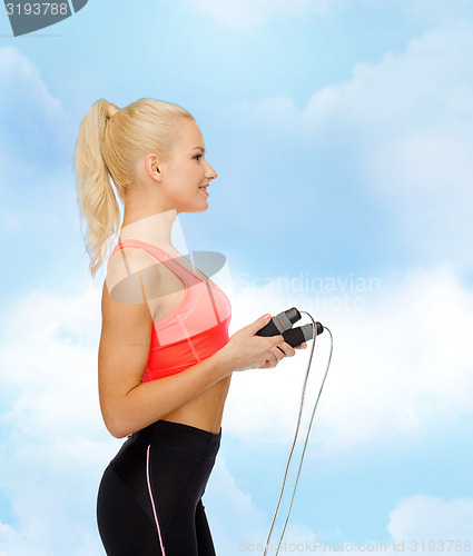 Image of smiling sporty woman with skipping rope