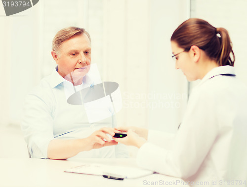 Image of female doctor or nurse measuring blood sugar value