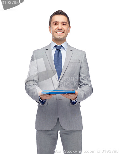 Image of happy businessman in suit holding tablet pc