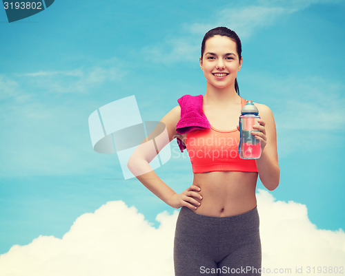 Image of sporty woman with towel and water bottle