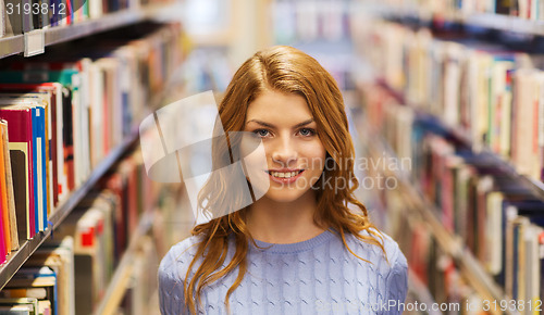 Image of happy student girl or young woman in library