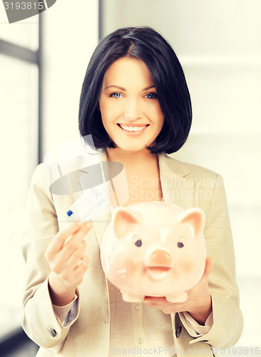 Image of lovely woman with piggy bank and money