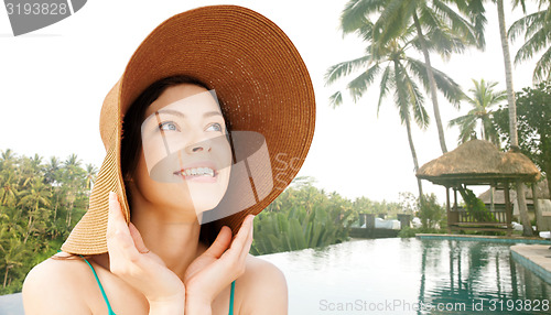 Image of happy young woman in straw hat on tropical beach