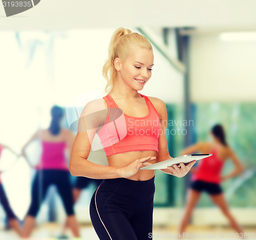 Image of smiling sporty woman with tablet pc computer