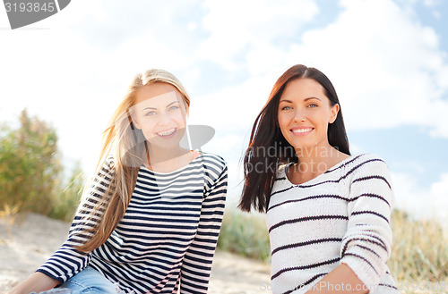 Image of happy teenage girls or young women on beach