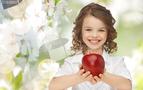 Image of happy girl holding apple over garden background