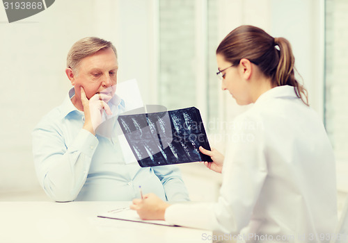 Image of female doctor with old man looking at x-ray