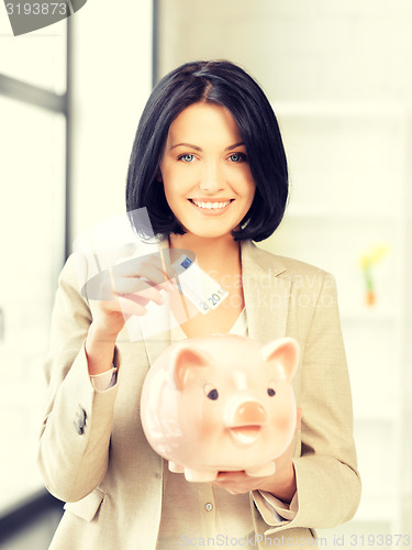 Image of lovely woman with piggy bank and money