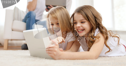 Image of smiling sister with tablet pc and parents on back
